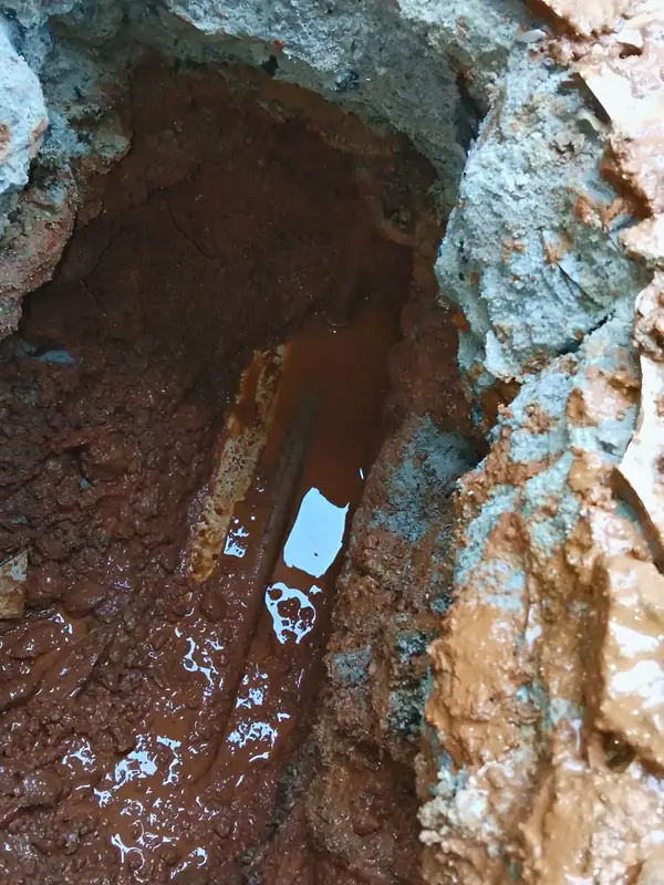 Água sob o contrapiso: Retirado só o trecho necessário, aparece a água acumulada e o cano com defeito.